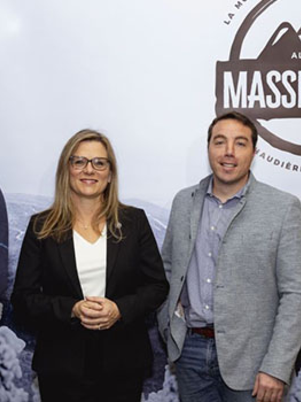 Quatre personnes debout devant une grande affiche de la Station touristique Massif‑du‑Sud.