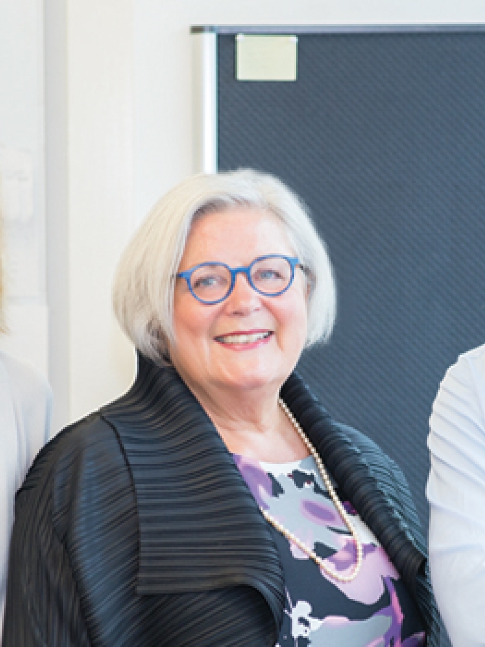 Trois personnes posent dans un environnement de laboratoire lumineux, devant du matériel scientifique.