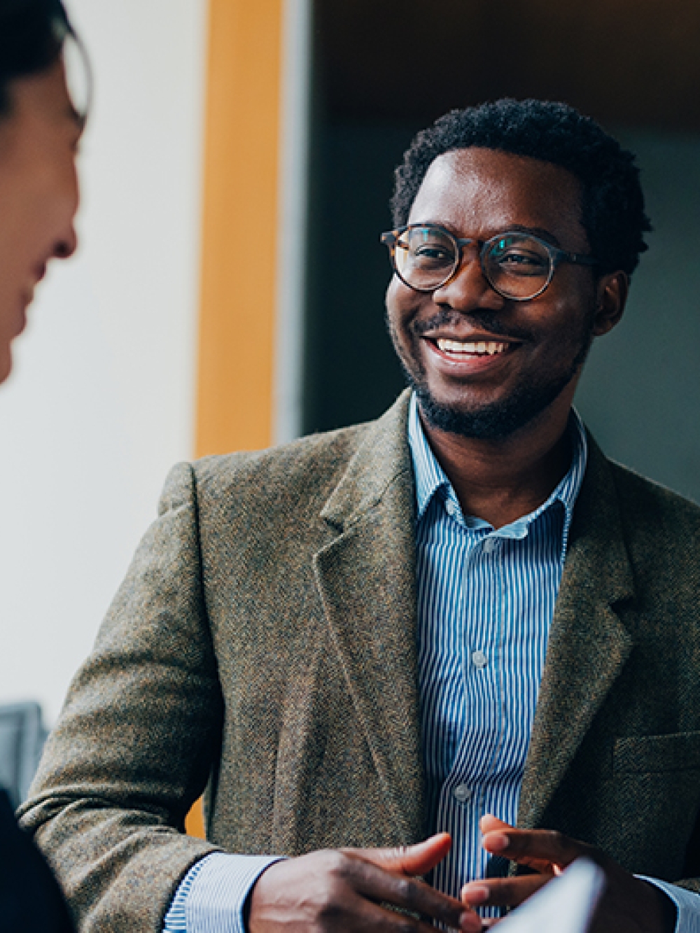 Des collègues de travail souriant durant une conversation