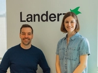 Deux personnes posant dans un bureau devant un mur affichant le logo de Landerz.