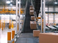 Convoyeur incliné transportant des cartons dans un entrepôt logistique moderne