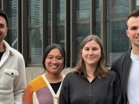 Groupe de quatre personnes debout devant une façade vitrée extérieure, posant ensemble pour une photo de groupe liée à l’entreprise Opalia.