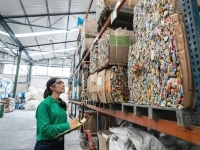 Une employée analyse la gestion des déchets dans un entrepôt