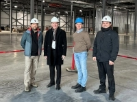 Groupe de personnes tenant un ruban bleu portant le nom « Duravit » lors d’une cérémonie d’inauguration à l’intérieur d’une usine.