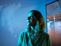 Une femme devant une carte du monde regarde au loin