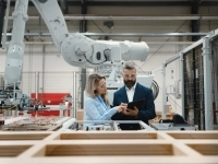 Deux ingénieurs regardant une tablette électronique dans un atelier de robotique