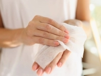 Femme utilisant une lingette sur ses mains